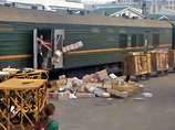 Мужчина, разгружающий вагон, быстро и небрежно выбрасывает коробки прямо на платформу, не беспокоясь о том, что находится в внутри