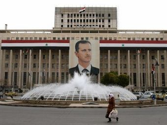 Здание Центрального банка Сирии с портретом президента страны Башара Асада. Архивное фото ©AFP