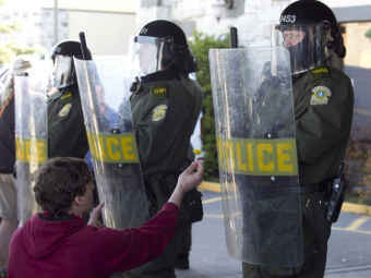 Участник акции в Викториявилле дарит одуванчик полицейским. Фото Reuters